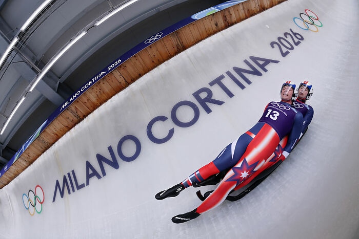 Two athletes competing in a Winter Olympic sport at Milano Cortina 2026, showcasing intense winter Olympic sports action.