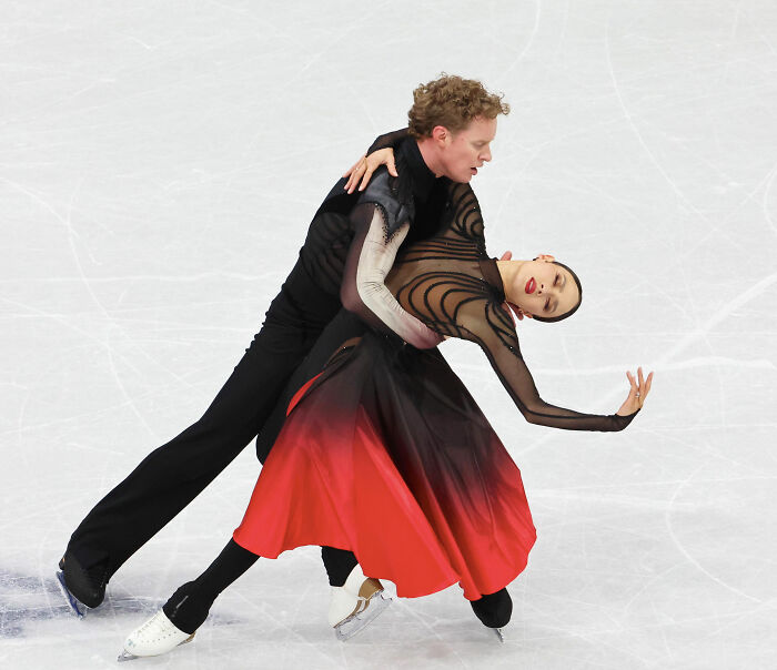 Figure skating Olympian performs dramatic dance pose amid cheating accusations and judge's controversial scores.