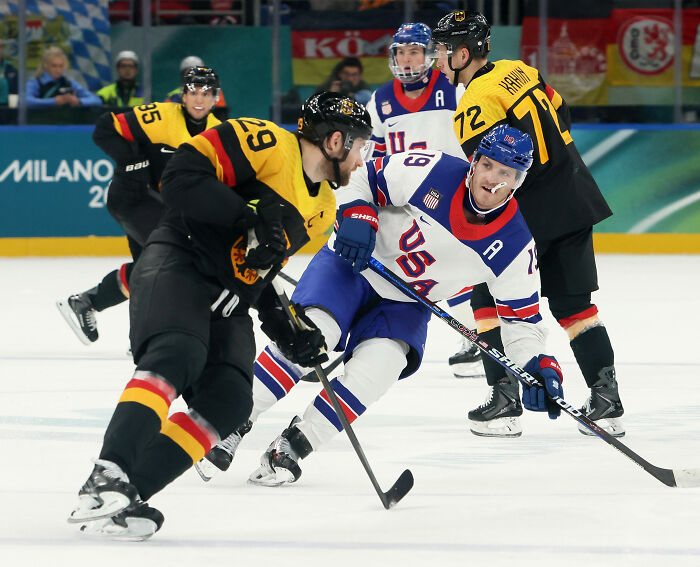 Olympic hockey rivals in a heated on-ice moment during intense competition at international tournament.