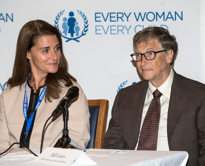 Bill Gates and his ex-wife seated at a panel discussing philanthropy, related to Epstein files and public accusations.