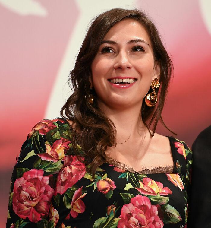 Smiling woman with floral dress and gold earrings photographed at an event discussing Tommy Lee Jones daughter&rsquo;s cause of passing.