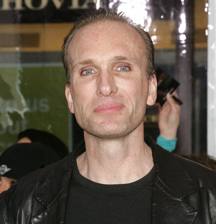 Peter Greene at an event, wearing a black shirt and jacket, with fans reacting to his cause of passing.