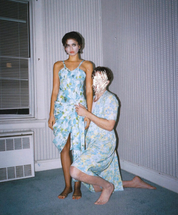 Zendaya and Robert Pattinson in gender-bending photoshoot wearing matching floral dresses in a minimal room setting.