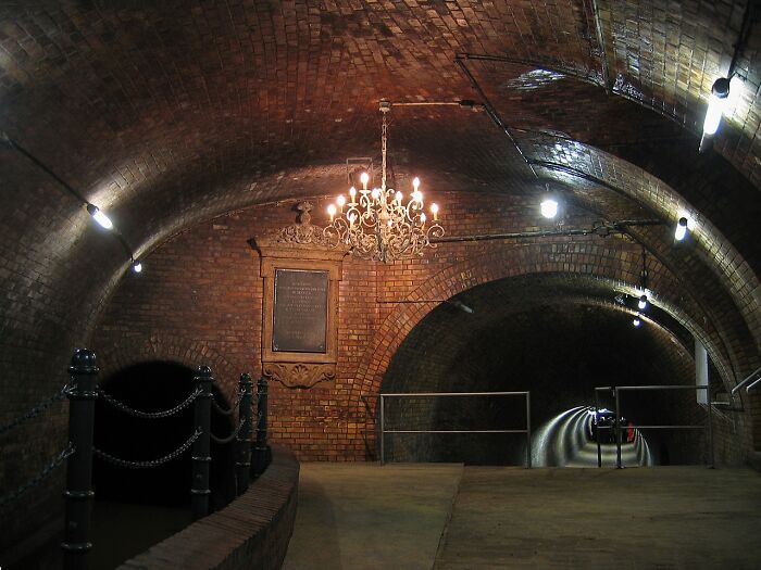 Underground brick tunnel with chandelier lighting, highlighting one of the unusual places featured worldwide.