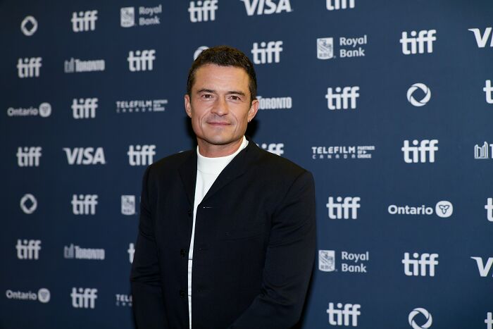 Actor posing at a TIFF event in front of a backdrop, representing iconic actors who dominated Hollywood but then vanished.
