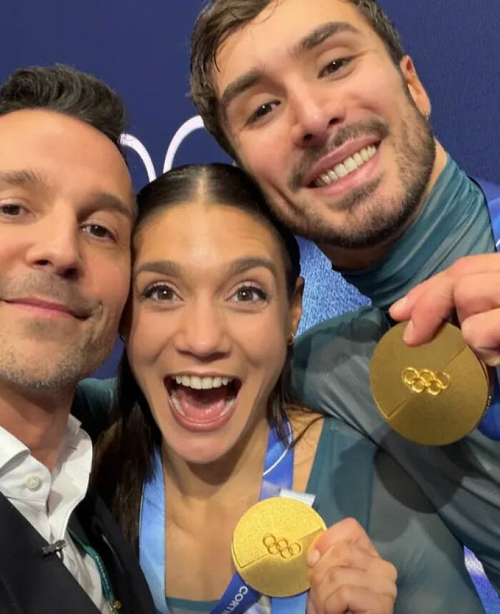Three US figure skaters smiling and holding gold medals after a cheating scandal involving Team USA figure skating.