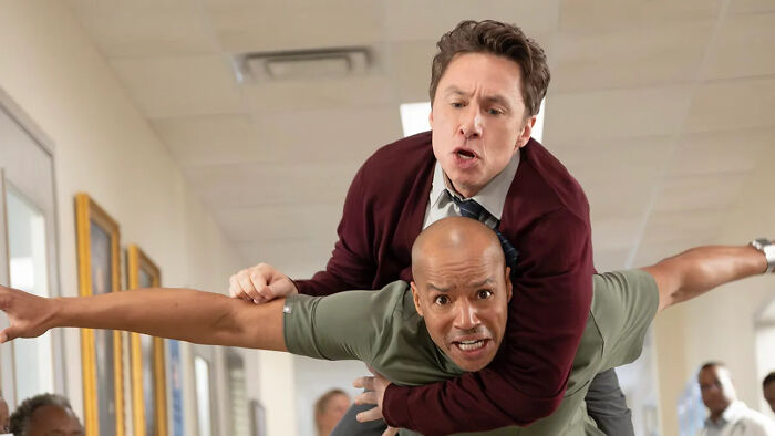 Two men playfully acting in a hospital hallway scene from Scrubs, highlighting Scrubs Season 10 episodes release info. Two men playfully acting in a hospital hallway scene from Scrubs, highlighting Scrubs Season 10 episodes release info.