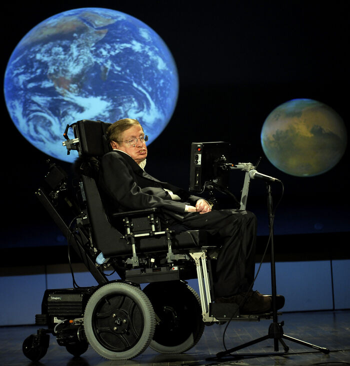 Physicist Stephen Hawking in a wheelchair with Earth and Mars in the background, relating to funny conspiracy theories.