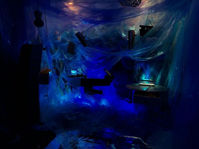 NYC apartment transformed into a Titanic movie set with blue lighting and plastic decor creating an oceanic atmosphere. NYC apartment transformed into a Titanic movie set with blue lighting and plastic decor creating an oceanic atmosphere.