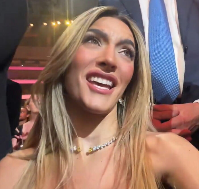 MAGA influencer Emily Austin smiling in a crowd, reacting during a public event with people around her.