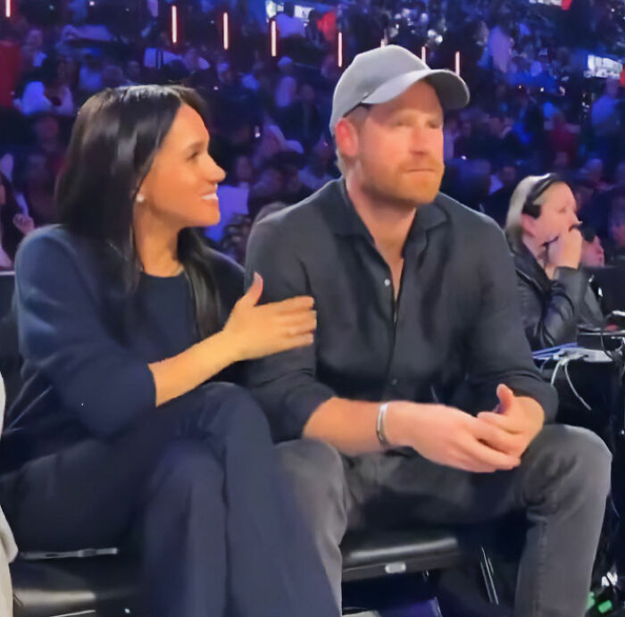 Prince Harry and Meghan Markle seated at NBA All-Star Game, displaying notable body language during the event. Prince Harry and Meghan Markle seated at NBA All-Star Game, displaying notable body language during the event.