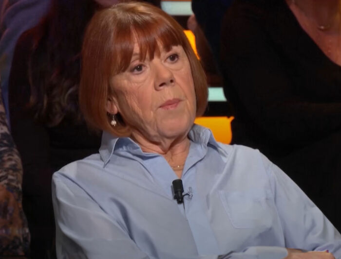 Gisèle Pelicot speaking during an interview, wearing a light blue shirt, sharing her story of exploitation by her husband and others.
