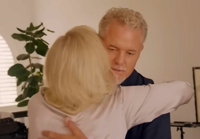 Eric Dane embracing a woman indoors, capturing a heartfelt moment before his tragic passing at 53.