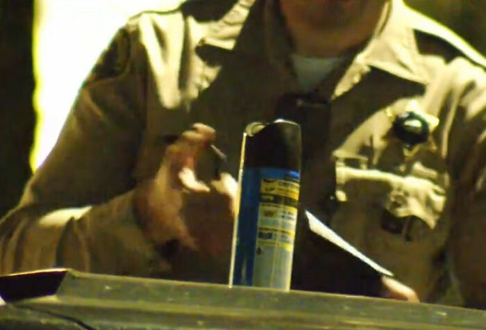 Security officer handling evidence spray can during investigation of roommate's horrifying acts on security footage. Security officer handling evidence spray can during investigation of roommate's horrifying acts on security footage.
