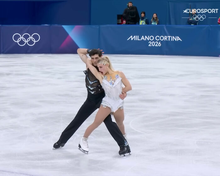 Olympic ice skater performing a graceful routine on the ice during Milano Cortina 2026 with partner.