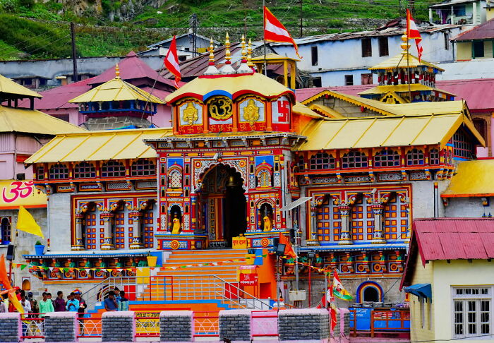 Colorful Hindu temple in India with devotees, showcasing spiritual tourism and cultural heritage through vibrant architecture.
