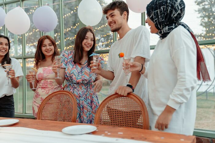 Group of young people enjoying a party with drinks and balloons, capturing wildest dating experiences and memorable moments.