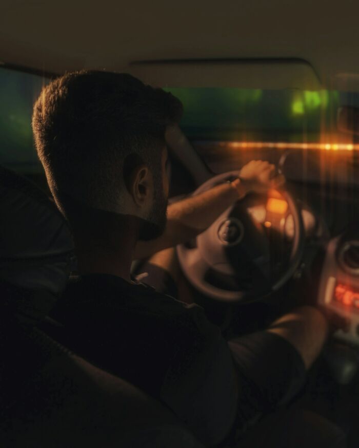 Man driving at night, tense and alert, capturing the chilling sounds that signal immediate disaster.