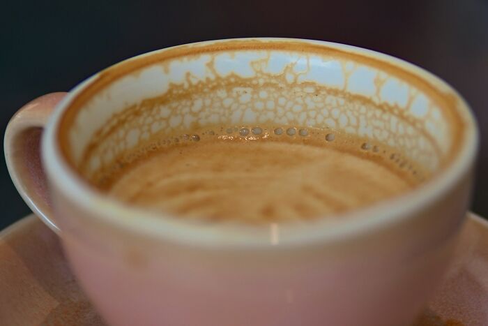 Close-up of a coffee cup with foam inside, illustrating underrated plane perks travelers should start taking advantage of.