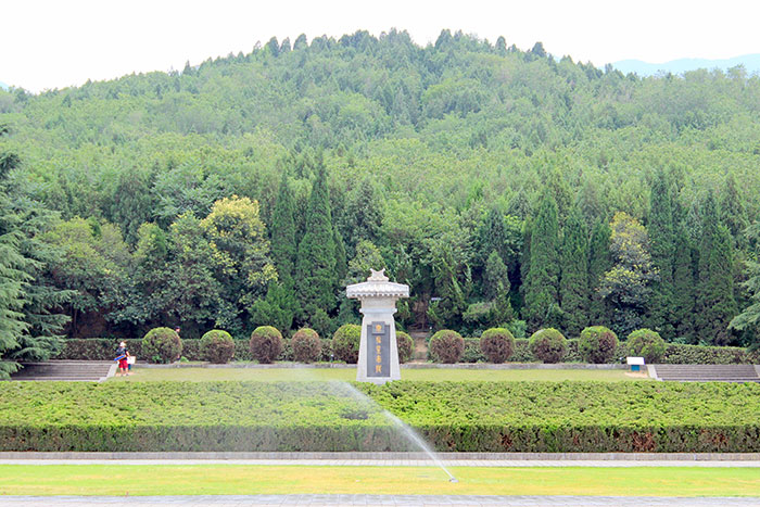 Stone monument surrounded by lush greenery, illustrating peaceful archaeological job site setting with potential traps nearby.