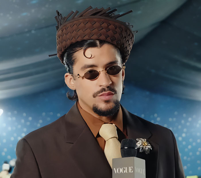 Bad Bunny wearing a brown suit and distinctive hat during his immaculate transformation after Grammy win.