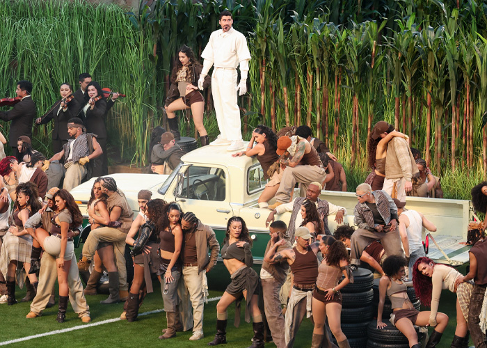 Performers on stage during the Super Bowl 2026 halftime show with a large group and outdoor set design.