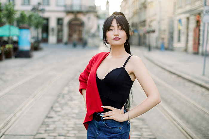 Woman standing confidently on a city street, illustrating challenges of beauty standards affecting women today. Woman standing confidently on a city street, illustrating challenges of beauty standards affecting women today.