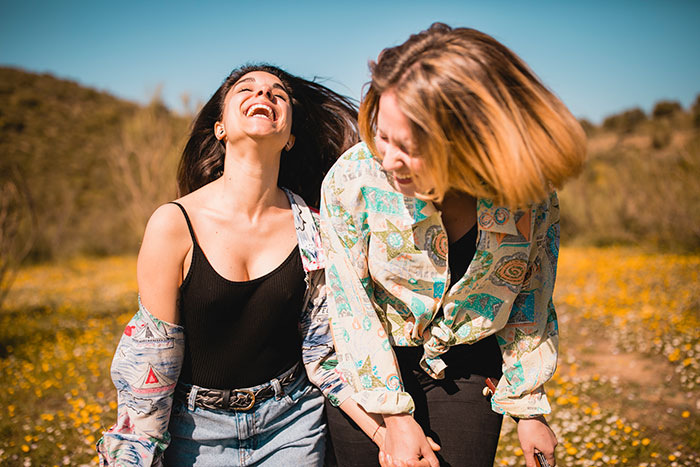 Two women laughing together outdoors, showing a best friend backup plan amid emotional hurt and support.