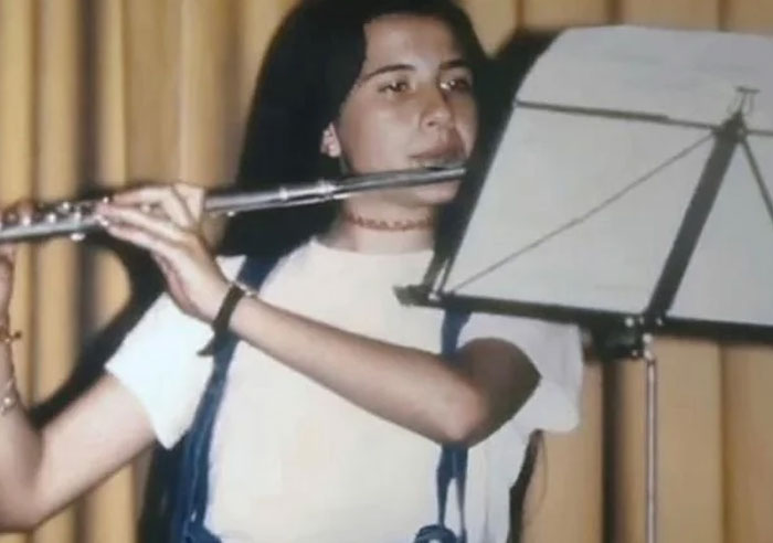 Young woman playing flute and reading sheet music, related to infamous unsolved mysteries from around the world.