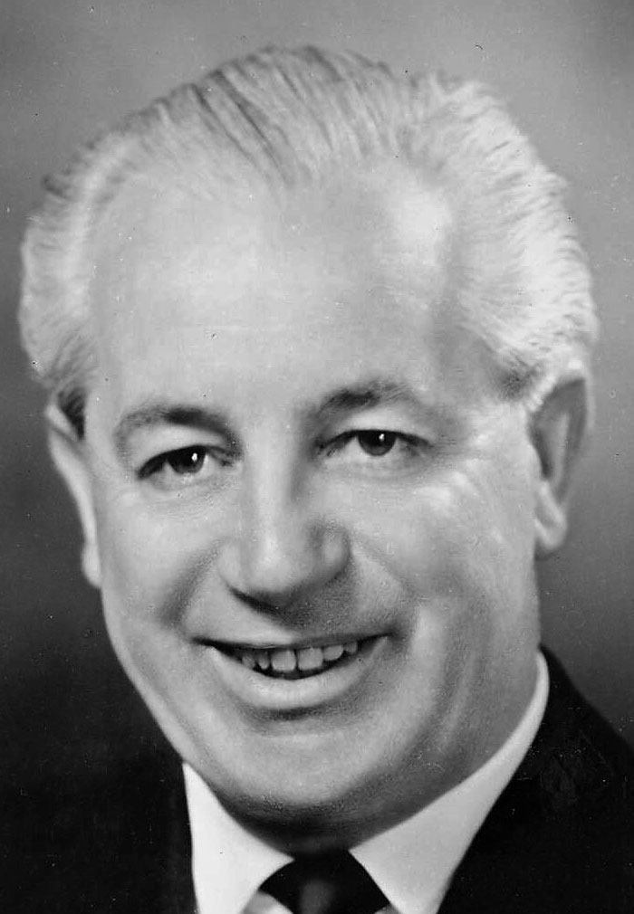 Black and white portrait of an older man smiling, related to infamous unsolved mysteries from around the world.