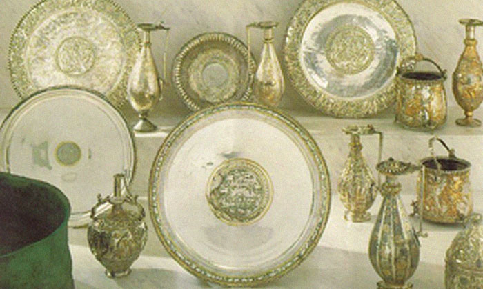 Ancient silver plates and ornate vessels displayed together, related to infamous unsolved mysteries from around the world.