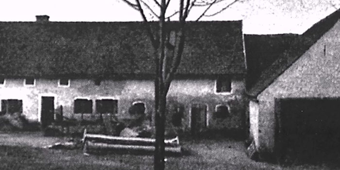 Black and white photo of an old house and yard, related to infamous unsolved mysteries around the world.