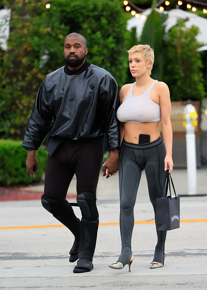 Bianca Censori in bold outfit walking hand in hand with Kanye, highlighting fashion amid Venice controversy.