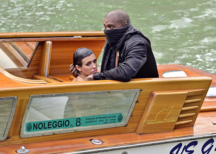 Bianca Censori in bold outfit on a wooden boat with Kanye during Venice incident on water.