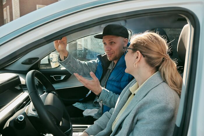 A man and woman having a first date conversation inside a car, capturing moments of awkward encounters and audacity.