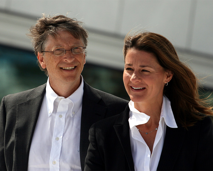 Bill Gates and Melinda French Gates together outdoors, both smiling and dressed in formal business attire. Bill Gates and Melinda French Gates together outdoors, both smiling and dressed in formal business attire.