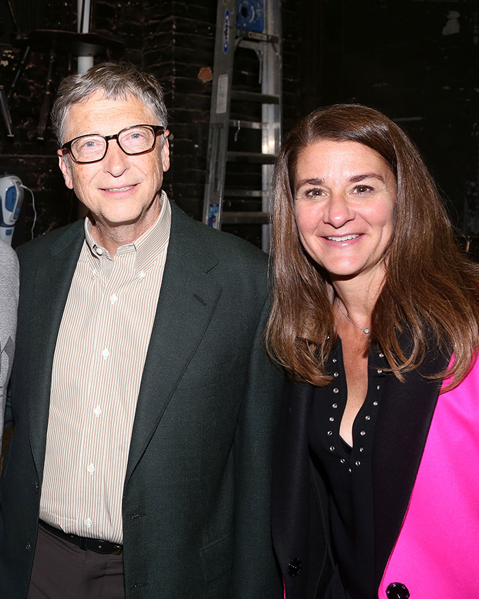 Melinda French Gates and Bill Gates smiling together indoors with dark background and casual attire. Melinda French Gates and Bill Gates smiling together indoors with dark background and casual attire.