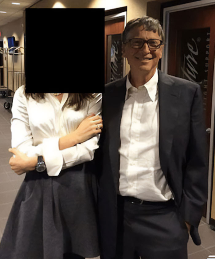 Bill Gates smiling in a suit standing next to a woman with face obscured indoors, related to Epstein files discussion.