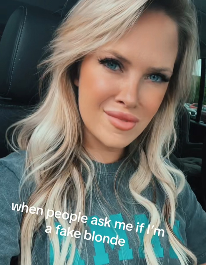 Dona de uma boutique loira com lábios visivelmente realçados, provocando escândalo na cidade ligado ao crescimento dos lábios em fotos.