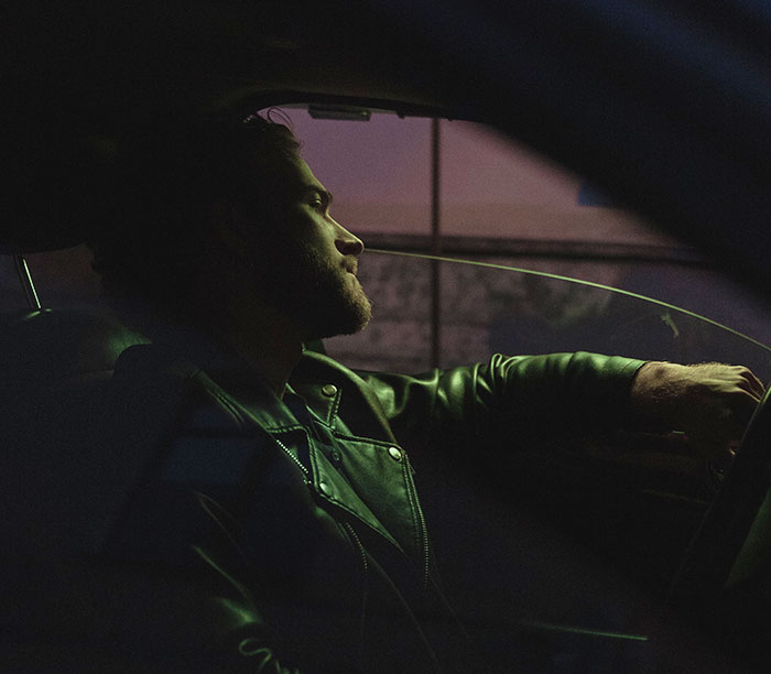 Man in a leather jacket driving away from restaurant after woman orders spaghetti despite her promise not to.