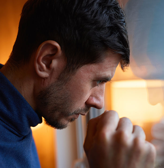 Man looking distressed and staring out window, reflecting on his girlfriend dressing like Ms Frizzle and facing reality check.