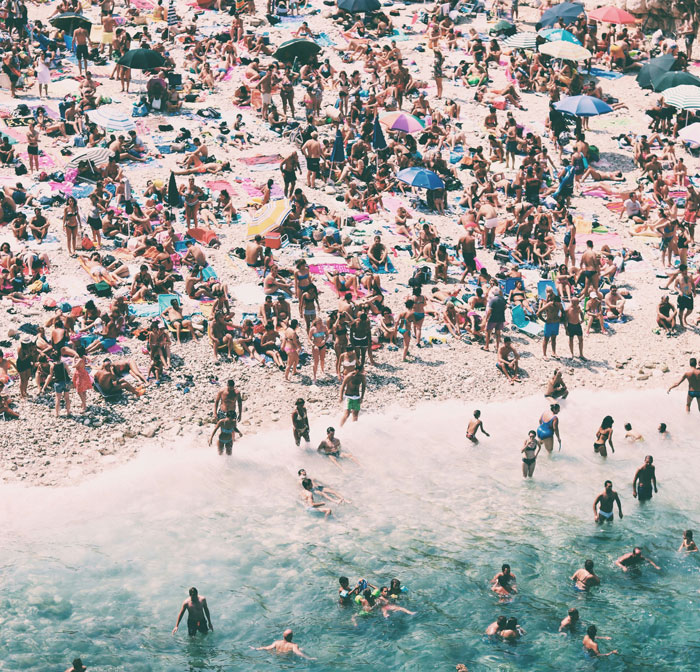 Crowded beach scene with many people swimming and relaxing, illustrating an effective way to deal with lost children.