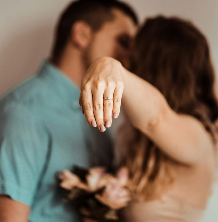 Woman showing engagement ring in front of her fianc&eacute;, highlighting drama at groom&rsquo;s brother wedding and baby shower event.