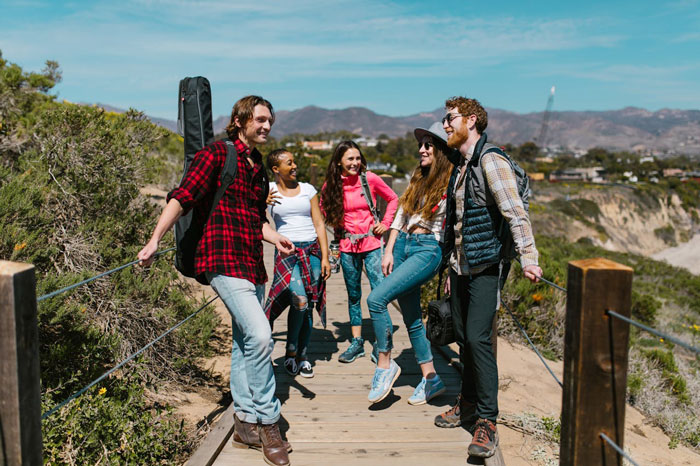 Group of friends hiking outdoors on a sunny day, capturing the groom&rsquo;s brother drama and baby shower moments.