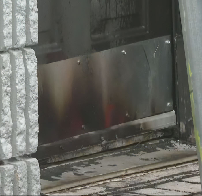 Close-up of damaged black metal door and c*****d white brick wall after fatal attack linked to disturbing criminal history of Roberta Esposito's son. Close-up of damaged black metal door and c*****d white brick wall after fatal attack linked to disturbing criminal history of Roberta Esposito's son.