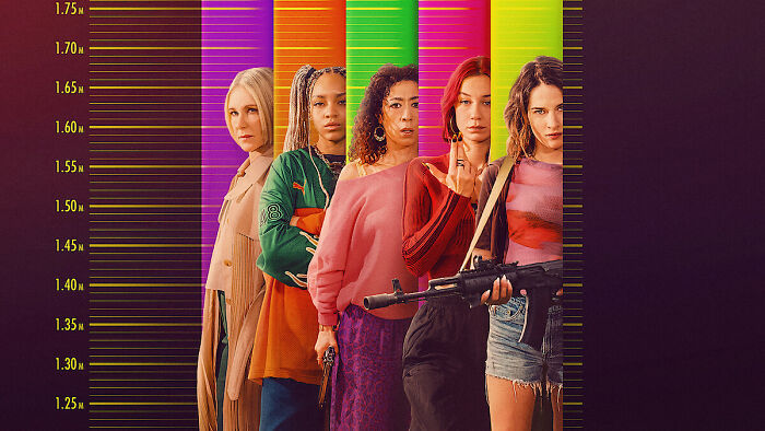 Five women standing in front of colorful height chart graphics, promoting what to watch on Netflix this weekend.