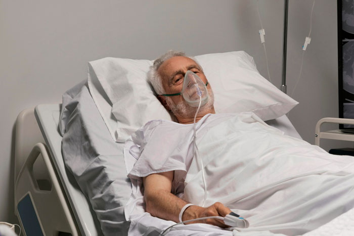 Elderly man resting in hospital bed with oxygen mask, illustrating illness related to child out of spite behavior. Elderly man resting in hospital bed with oxygen mask, illustrating illness related to child out of spite behavior.