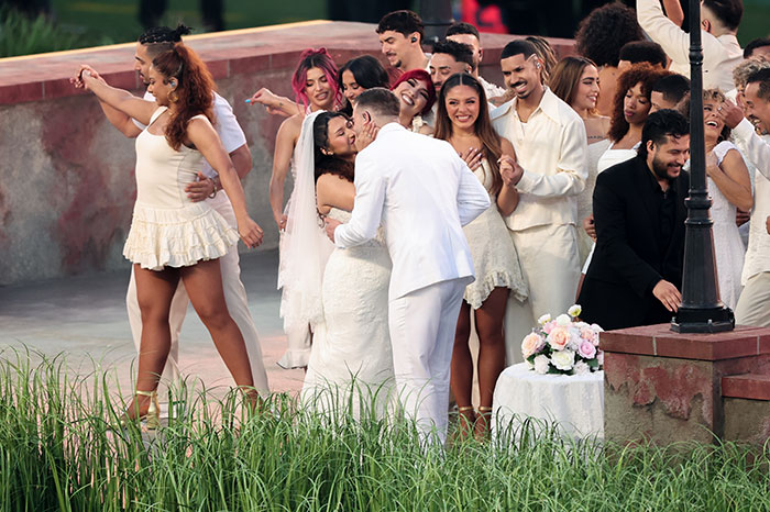 Couple kissing during a staged wedding scene with dancers and musicians at Bad Bunny's Super Bowl halftime show.