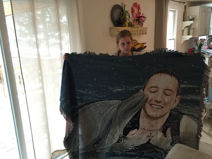 Person holding a personalized blanket gift featuring a humorous dolphin photo, perfect for funny Valentine’s Day gifts.