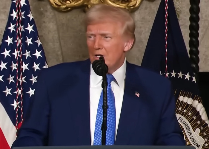 Man speaking at a podium with US flags behind him, related to legal expert discussing dad who won't face charges.